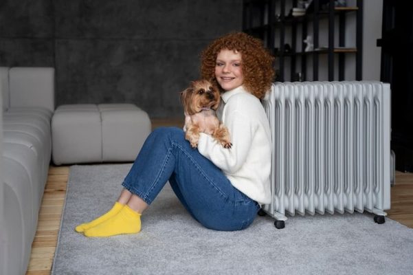 mujer con su perro junto a calefacción